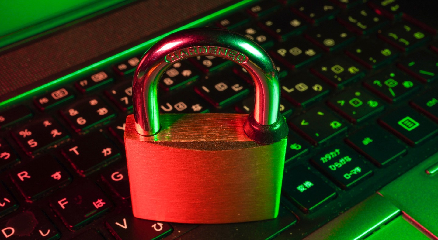 A closed padlock sits on top of a computer keyboard.