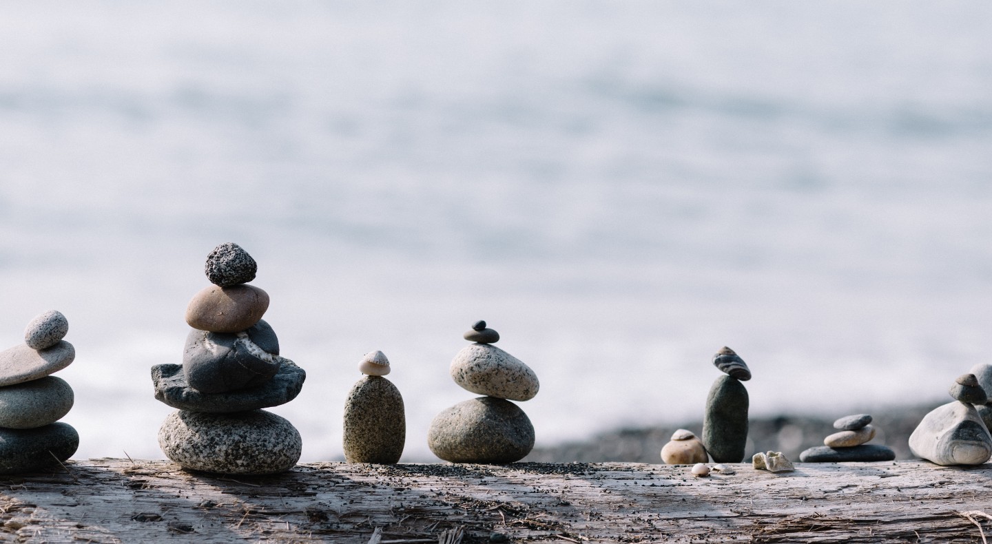 A selection of rocks balanced on top of each other, by the sea.