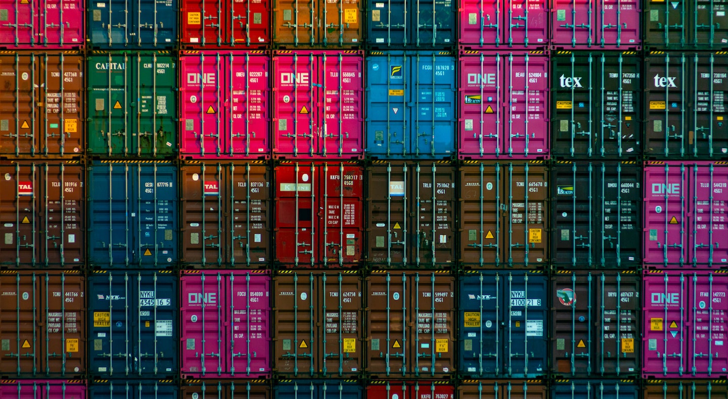 A photo of many containers stacked next to each other and on top of each other, symbolizing the ease with which Devs can use containers for web apps.