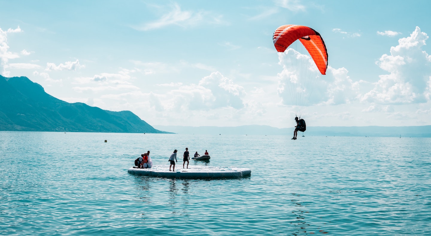 A paraglider is about to land on a lake platform in Switzerland