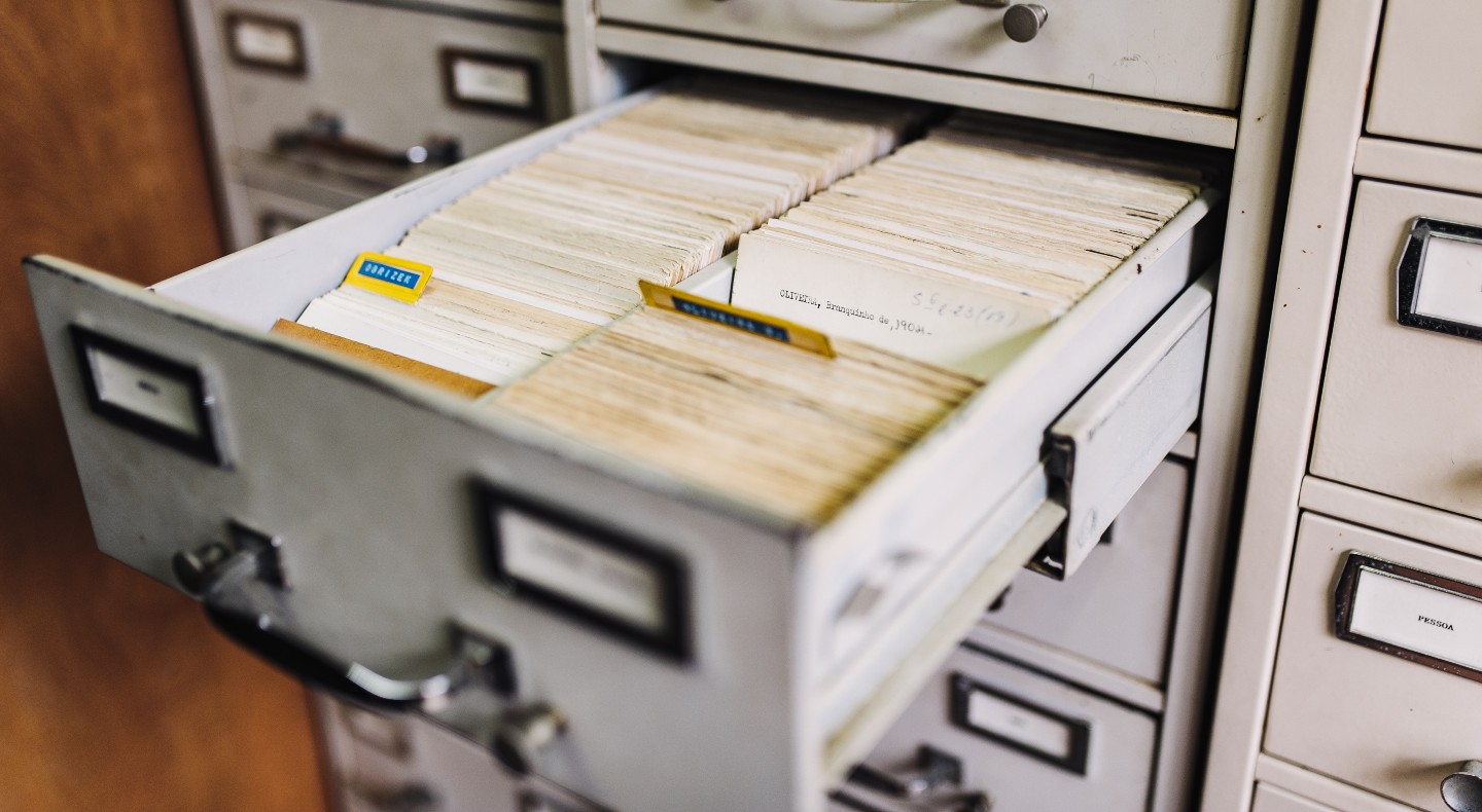A filing cabinet drawer is open, showing old fashioned files